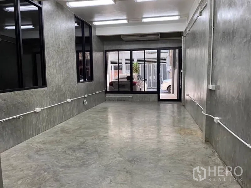 办公空间 出租在Yan Nawa, Bangkok - 一层开放工作区，抛光水泥地，临街大面积玻璃与推拉门，顶置灯光。