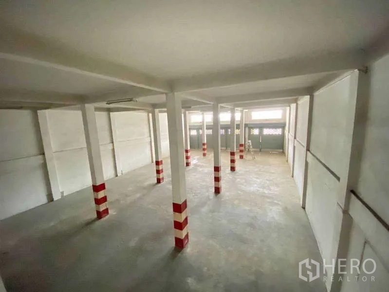 Warehouse for rent in Phasi Charoen, Bangkok - Wide view of the warehouse hall showing clerestory windows and several roller shutters.