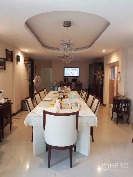 บ้าน ขายในSuan Luang, Bangkok - ห้องรับประทานอาหารยาว โต๊ะรองรับหลายที่นั่ง ใต้ฝ้าหลุมพร้อมโคมระย้า