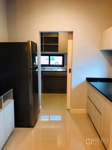 独立式住宅 出租或出售在Pathum Thani - 备餐间/第二厨房，黑色操作台与推拉门