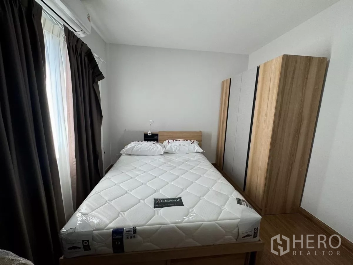 Detached House for rent in Bang Phli, Samut Prakan - Second bedroom view highlighting a large wardrobe and bedside table.