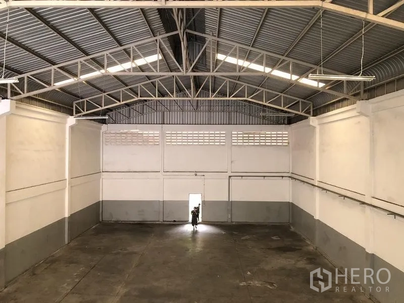 工厂 出租在Pathum Thani - 高挑仓库区，钢结构屋架与混凝土地面。