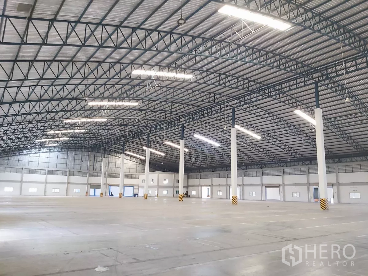 Warehouse for rent in Bang Bo, Samut Prakan - Large column-free warehouse space with tall white pillars and roof lights.