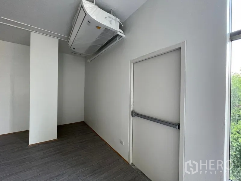 办公空间 出租在Bang Rak, Bangkok - 带推杆的安全出口门，位于空调机下方。