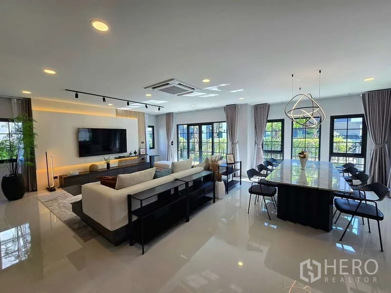 独立式住宅 出租在Bang Phli, Samut Prakan - 开放式客餐厅，超大中岛餐桌，落地窗与筒灯。