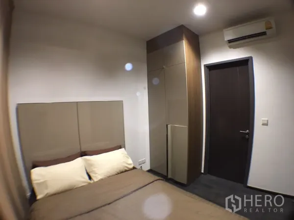 公寓 出租在Watthana, Bangkok - 卧室配双人床、软包床头、内置衣柜与壁挂空调。