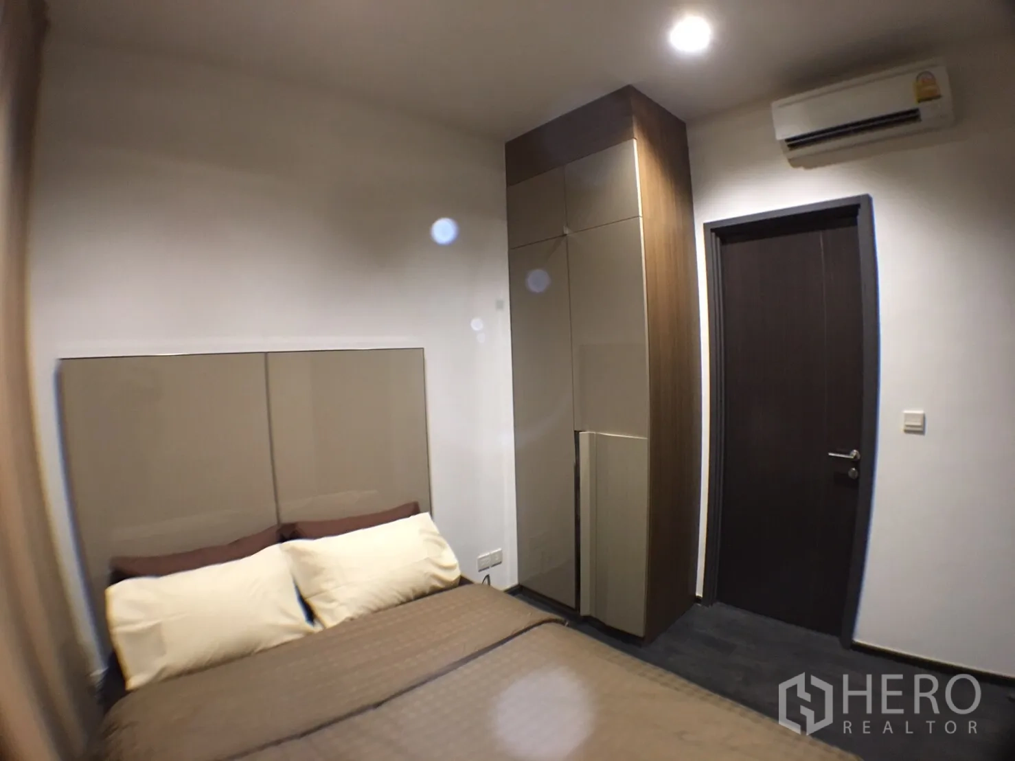 公寓 出租在Watthana, Bangkok - 卧室配双人床、软包床头、内置衣柜与壁挂空调。