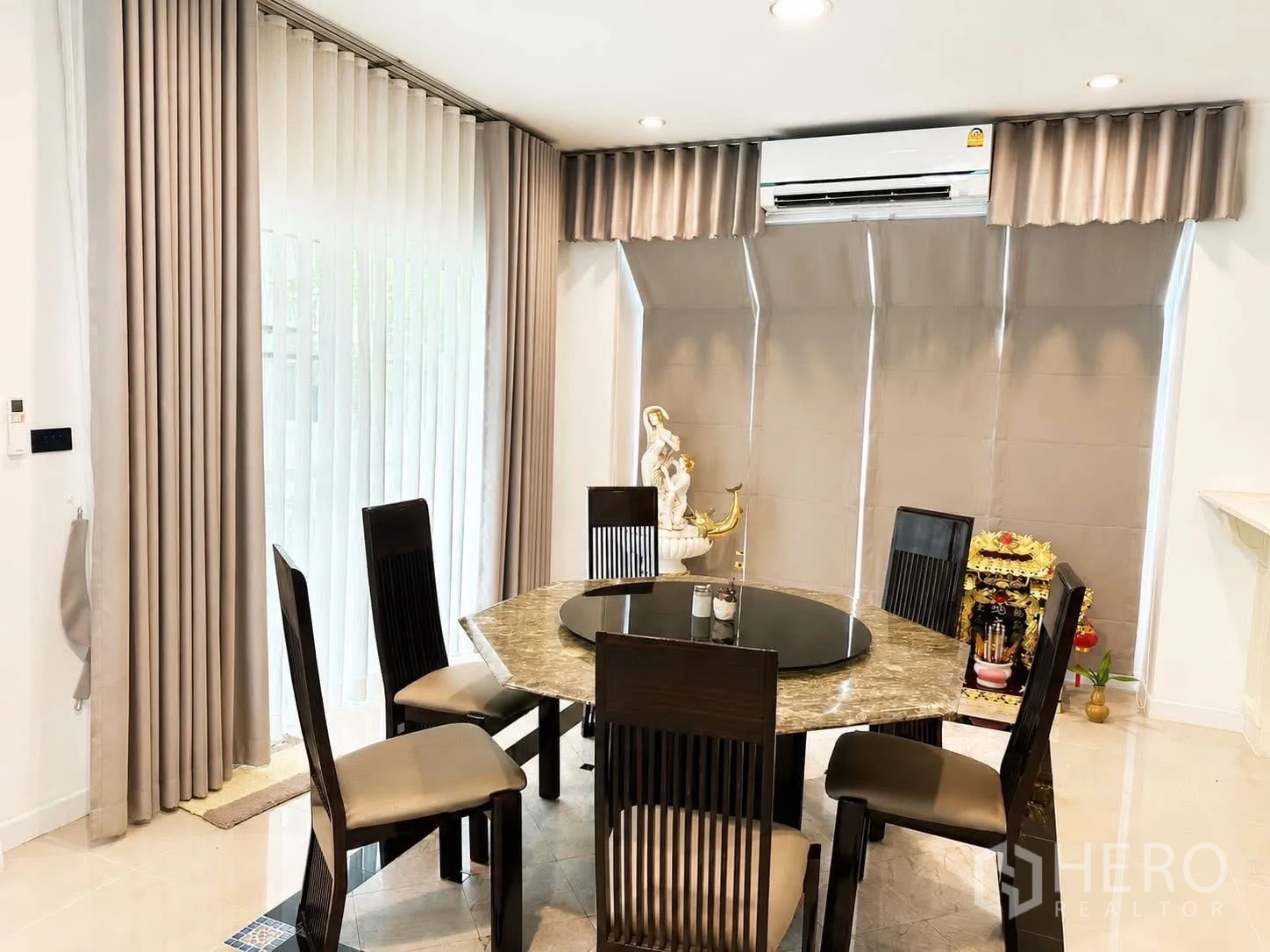 独栋房屋 for rent in Prawet, Bangkok - 餐厅设圆形大理石餐桌、六把椅子与落地窗，带空调。