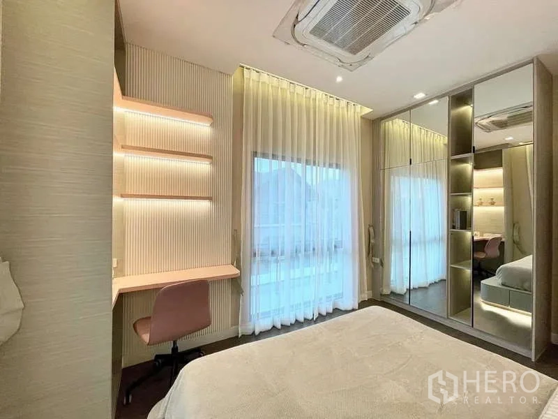 独立式住宅 出租在Bang Phli, Samut Prakan - 明亮卧室，镜面衣柜、靠窗书桌与吊顶空调。