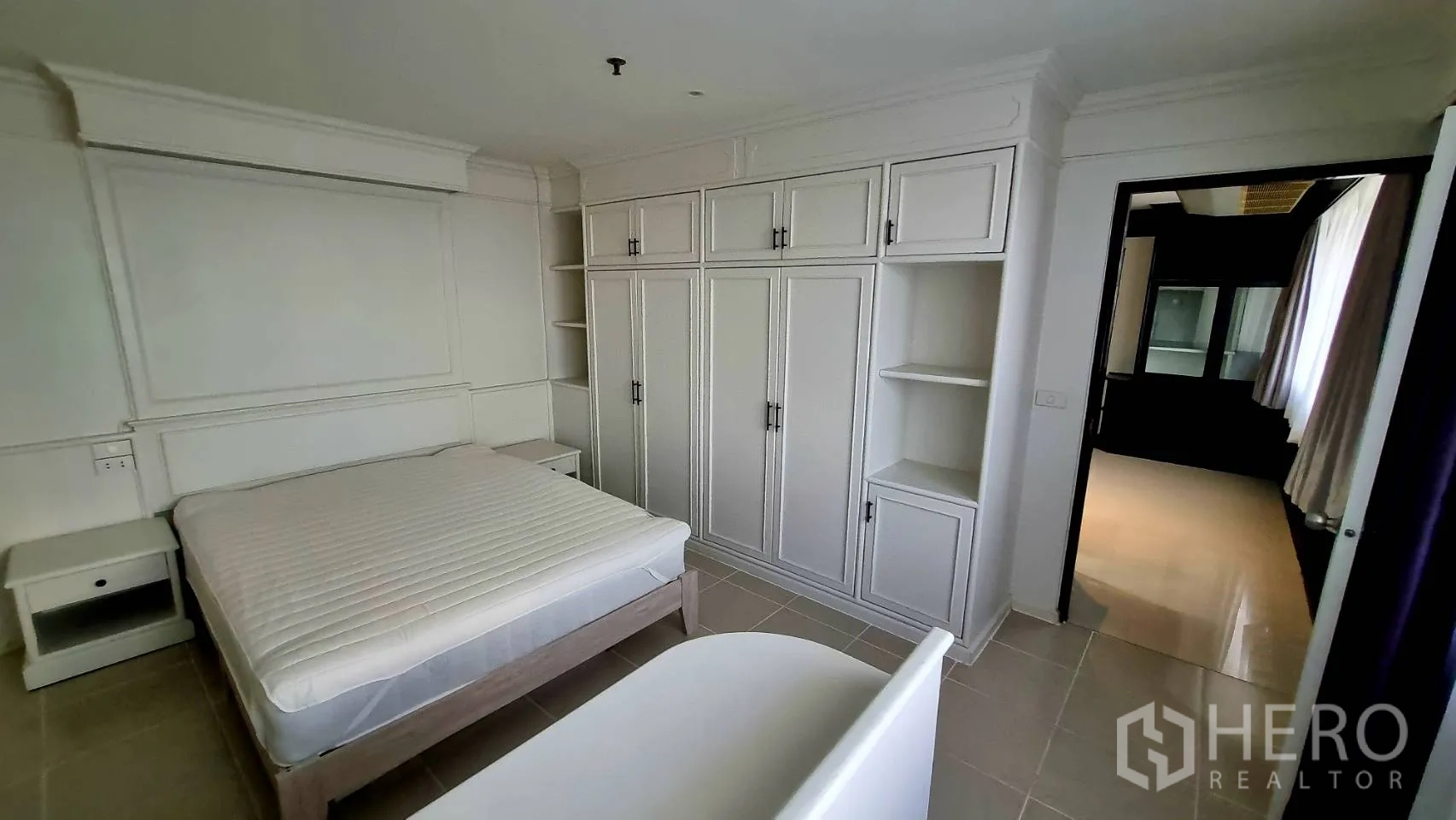 Condominium for rent in Watthana, Bangkok - Bedroom with wall-to-wall wardrobes and shelving.