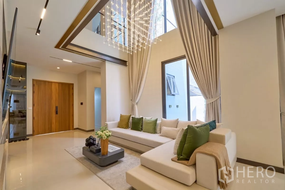 Detached House for sale in Lat Phrao, Bangkok - Double-height foyer with statement chandelier and floor-to-ceiling curtains.