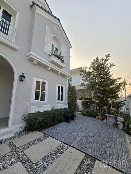 Detached House for rent in Bang Phli, Samut Prakan - Front courtyard with stone pavers, shrubs and arched porch of the house.