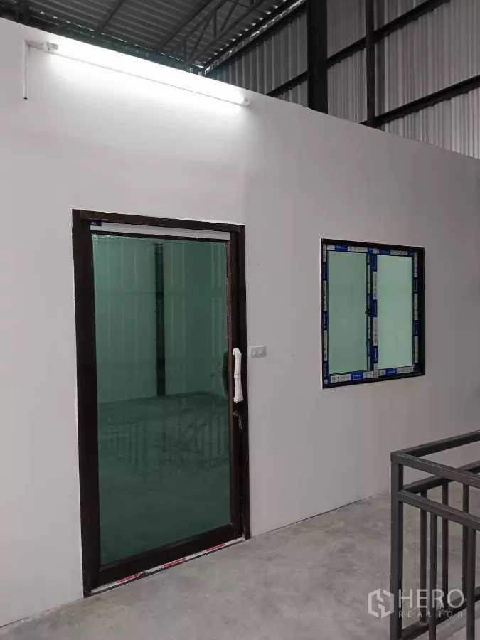 Warehouse for rent in Bang Phli, Samut Prakan - Mezzanine level with glass door and window to the office above the warehouse floor.