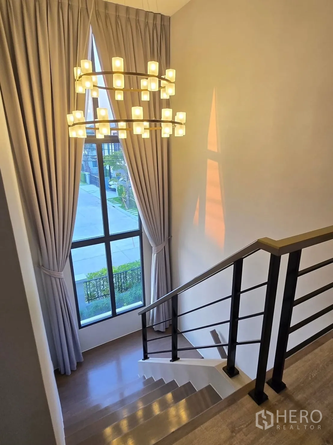 บ้าน for rent or sale in Bang Phli, Samut Prakan - บันไดราวเหล็กสไตล์โมเดิร์น หน้าต่างสูง และโคมระย้าทรงวงคู่