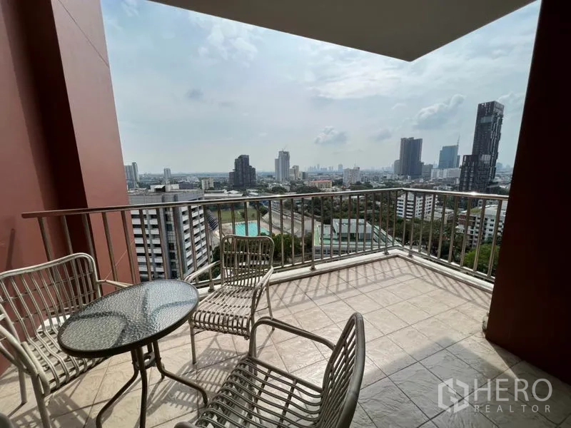 公寓 出租在Watthana, Bangkok - 大面积遮蔽阳台，户外桌椅俯瞰曼谷天际线。