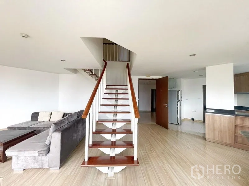 Condominium for rent in Khlong Toei, Bangkok - Central view of open staircase rising from the living room of the duplex.