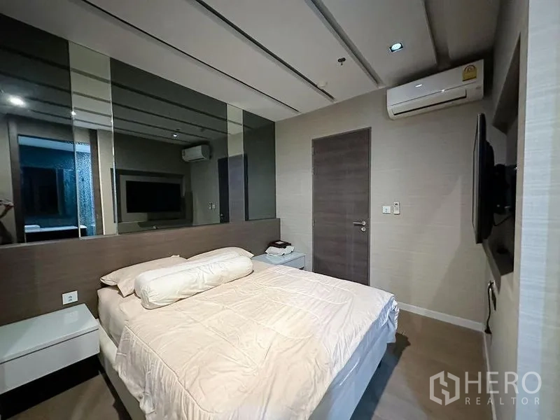 公寓 出租或出售在Khlong Toei, Bangkok - 温馨卧室，配床、镜面墙、空调与壁挂电视。