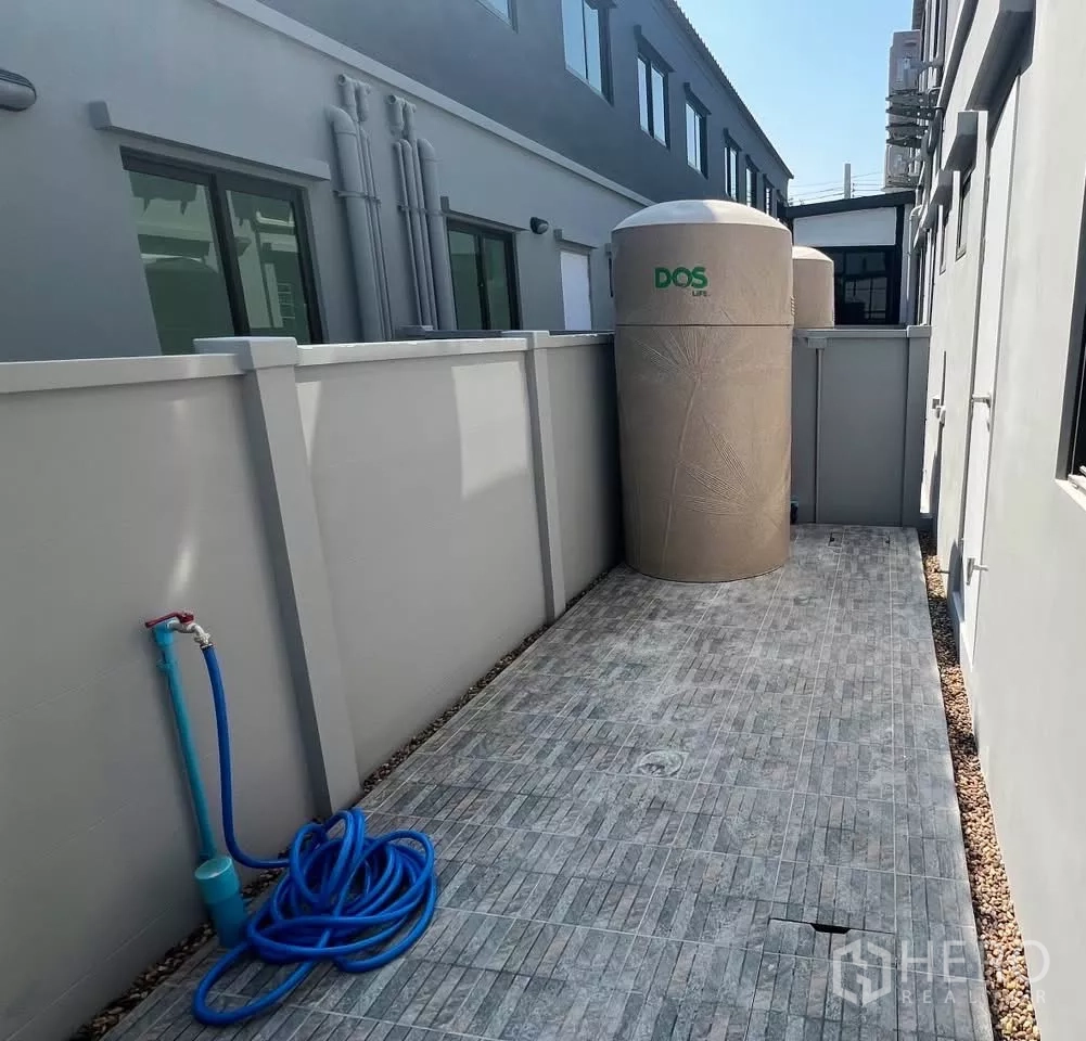 Townhouse for rent in Bang Phli, Samut Prakan - Back utility terrace with water tank, hose and tiled floor for laundry.