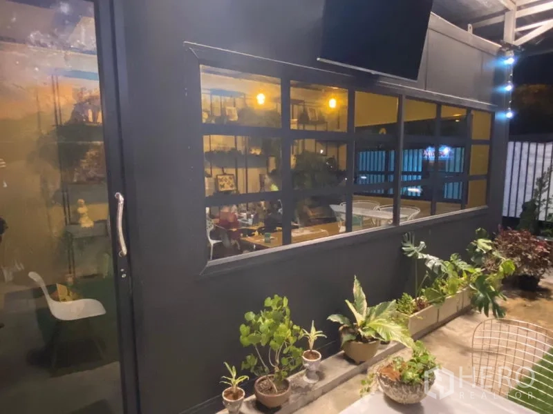 Retail Space for rent in Khlong Toei, Bangkok - Black exterior facade with large grid windows and planters along the patio walkway.