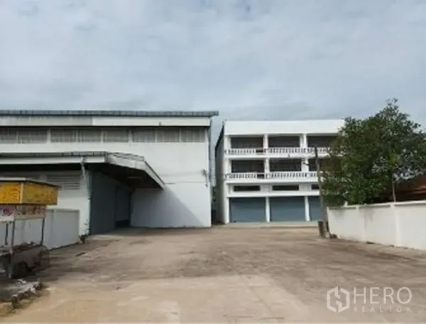 Warehouse for rent in Khlong Sam Wa, Bangkok - Front view of gated industrial compound with wide driveway, warehouse and multi‑storey office building.
