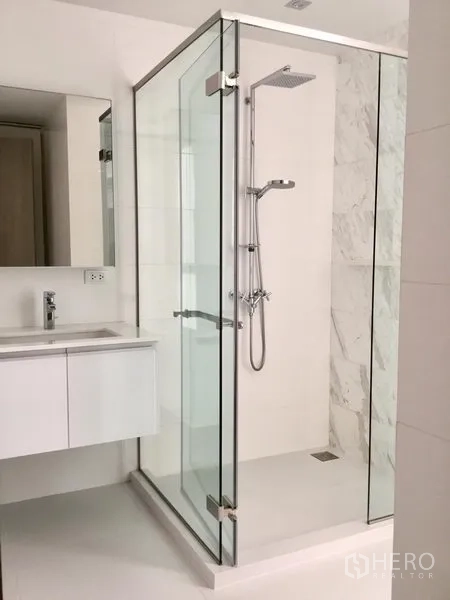公寓 出租或出售在Watthana, Bangkok - 洁白浴室配玻璃淋浴房与悬挂式洗手台。