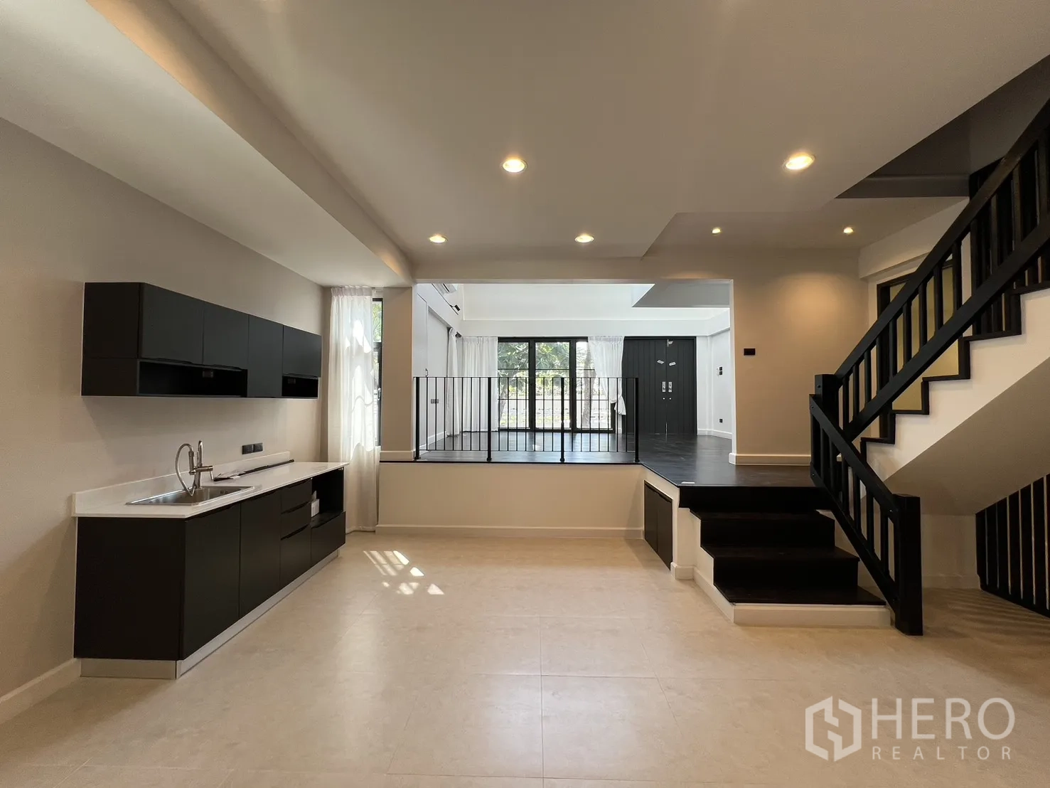Detached House for rent in Saphan Sung, Bangkok - Family area with kitchenette and steps leading to a raised lounge with sliding doors.