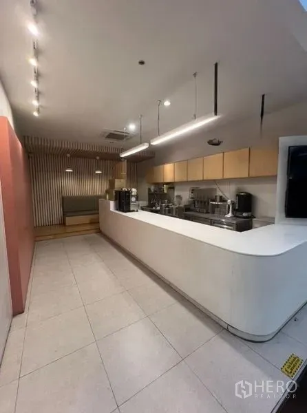 Retail Space for rent in Watthana, Bangkok - Service counter and back‑of‑house pantry with pendant lights, storage cabinets, and equipment.