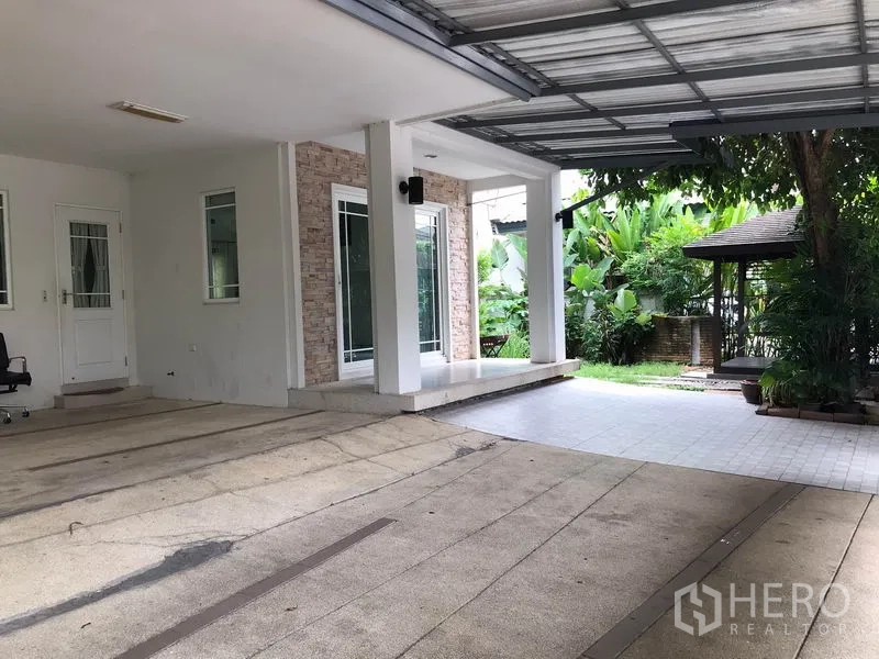 独立式住宅 出租在Khlong Sam Wa, Bangkok - 带顶停车位与邻接花园的铺砖露台，可见凉亭。