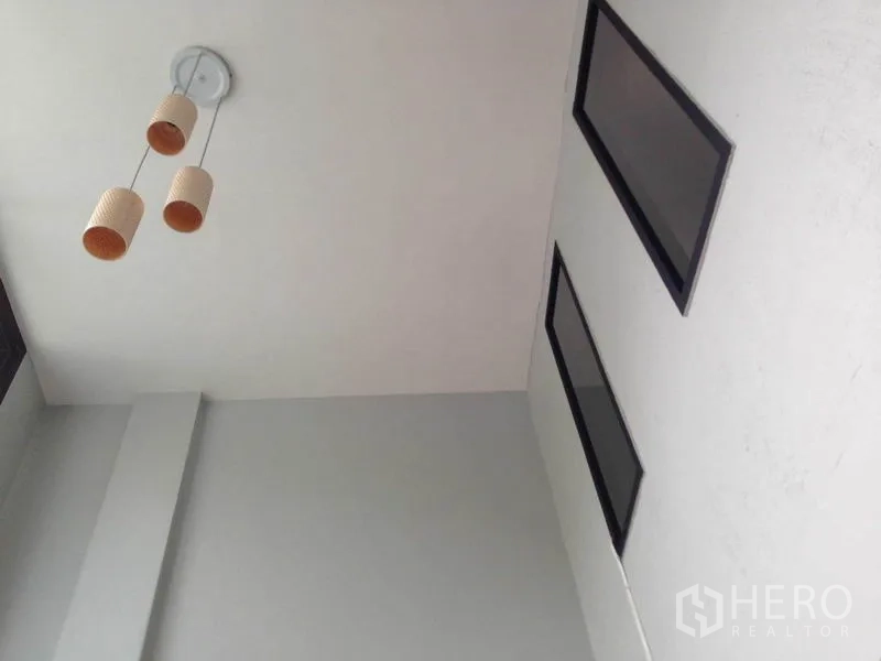 带办公室的家 出租或出售在Wang Thonglang, Bangkok - 仰视天花，三头吊灯与高挑矩形窗户带来自然采光。