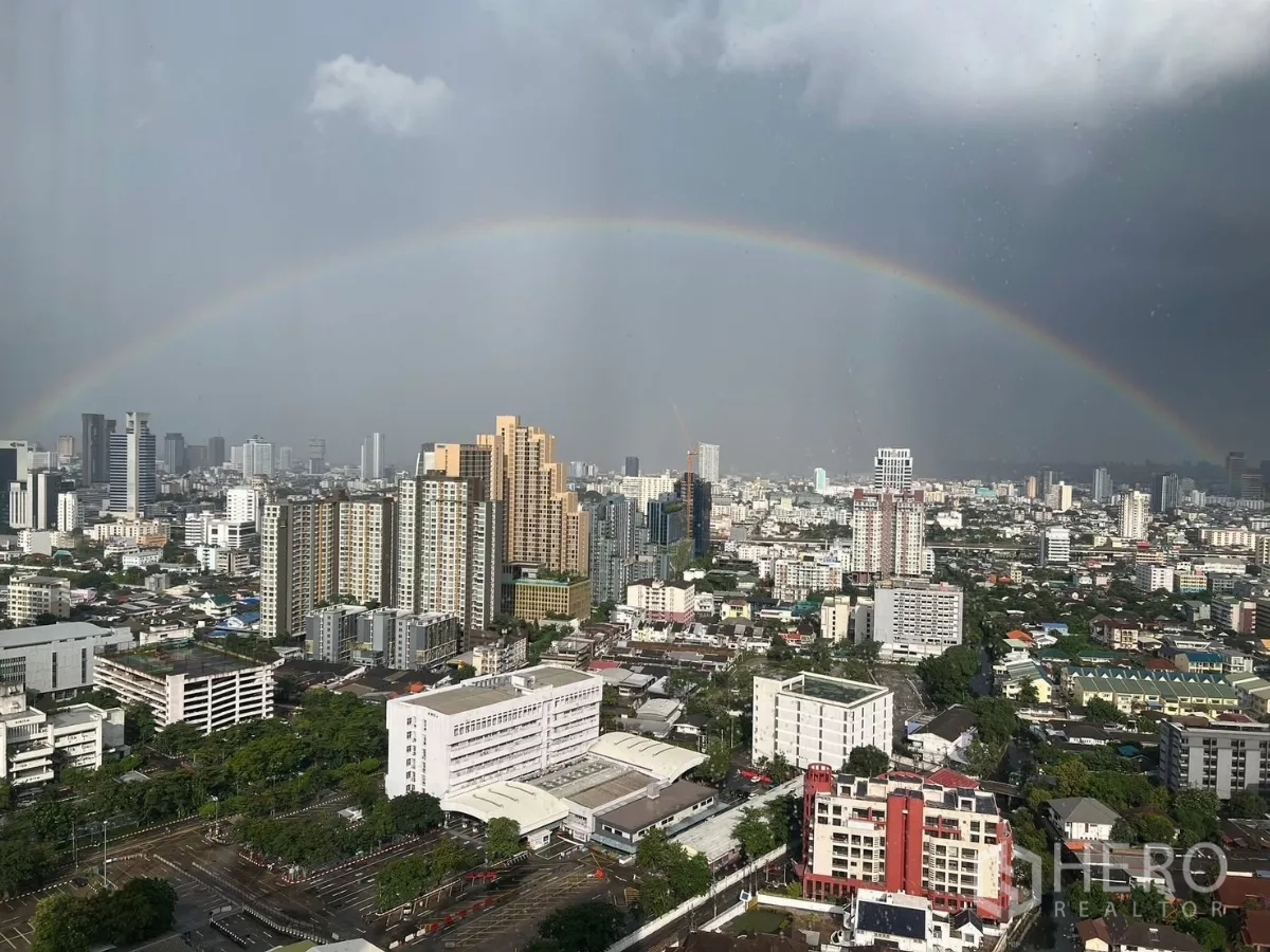 Condominium for rent or sale in Chatuchak, Bangkok - High‑floor skyline view of Chatuchak, Bangkok with a rainbow after rain.