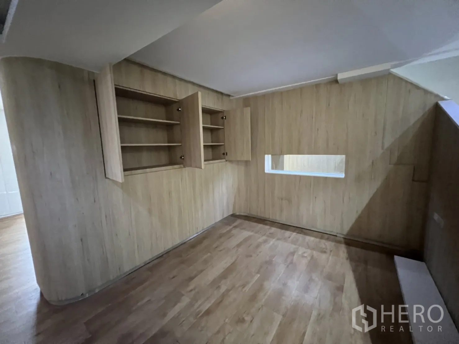 Shophouse for rent or sale in Watthana, Bangkok - Wood-paneled room with open shelving and an interior viewing window.