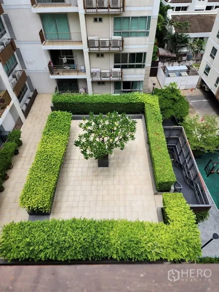 Condominium for rent in Watthana, Bangkok - Top-down view of a neat courtyard with trimmed hedges and a central tree.