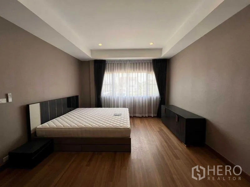 Detached House for sale in Mueang Pathum Thani, Pathum Thani - Primary bedroom with platform bed, wide window and minimalist decor