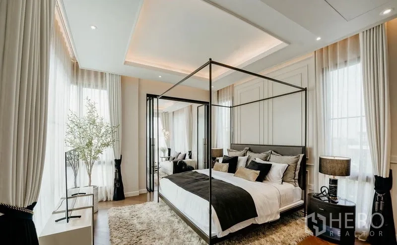 Detached House for sale in Saphan Sung, Bangkok - Light-filled master bedroom with four-poster bed, large windows and neutral decor.
