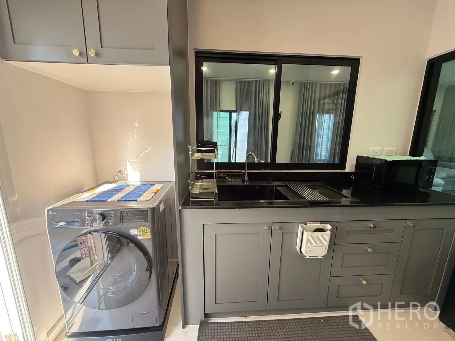 บ้านเดี่ยว for rent in Bang Phli, Samut Prakan - ส่วนยูทิลิตี้และครัวมีอ่างล้างจาน ตู้เก็บของ และเครื่องซักผ้าฝาหน้า.