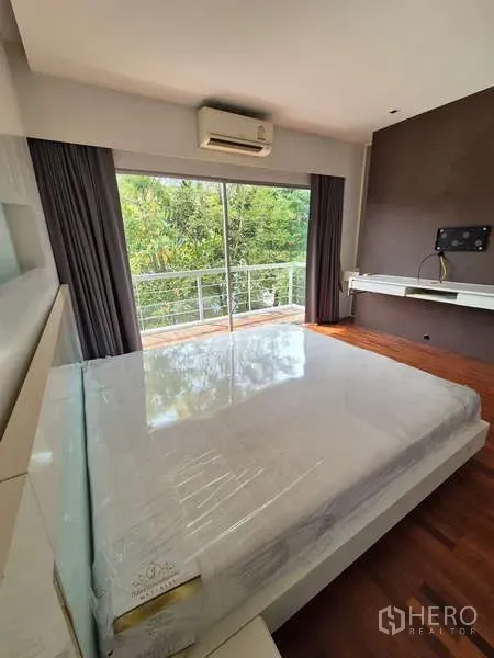 Detached House for rent in Bang Kruai, Nonthaburi - Bedroom opening to a balcony through sliding glass doors with lush garden view.
