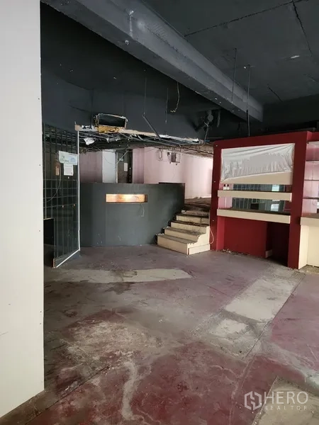 零售空间 出租在Khlong Toei, Bangkok - 店内设有台阶通往抬高区域，服务台及外露管线天花。