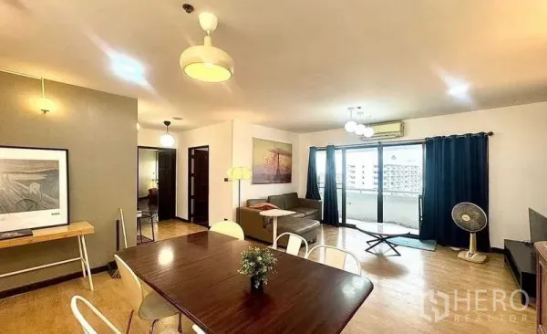 Condominium for rent or sale - Airy living and dining zone with balcony doors, wood floors and modern lighting.