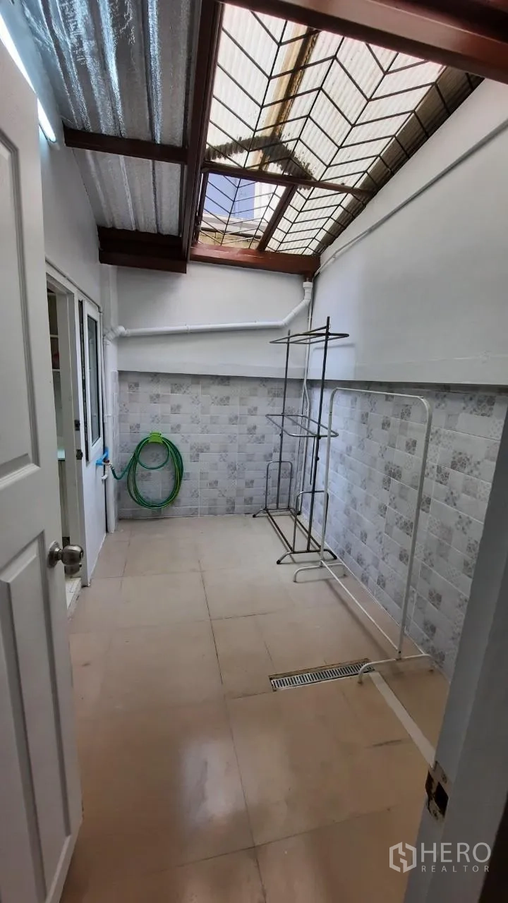 Townhouse for sale in Suan Luang, Bangkok - Laundry and utility area under skylight roof with tiled walls