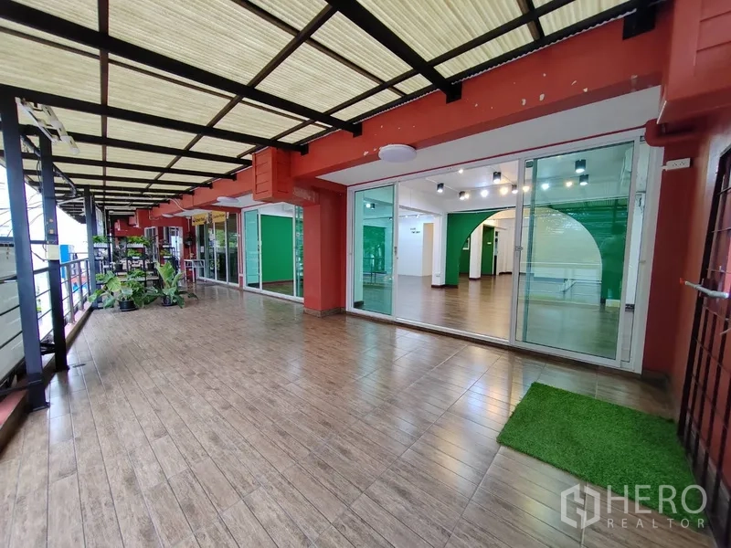 Retail Space for rent in Khlong Toei, Bangkok - Covered terrace with wood-look tiles and glass storefront leading into retail space