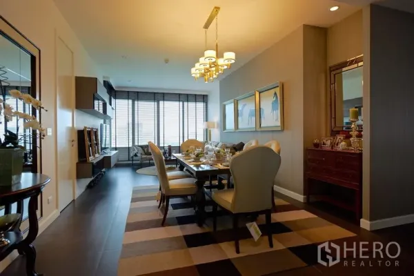 Condominium for rent in Pathum Wan, Bangkok - Formal dining area with chandelier, large windows and modern shelving leading to the living space.