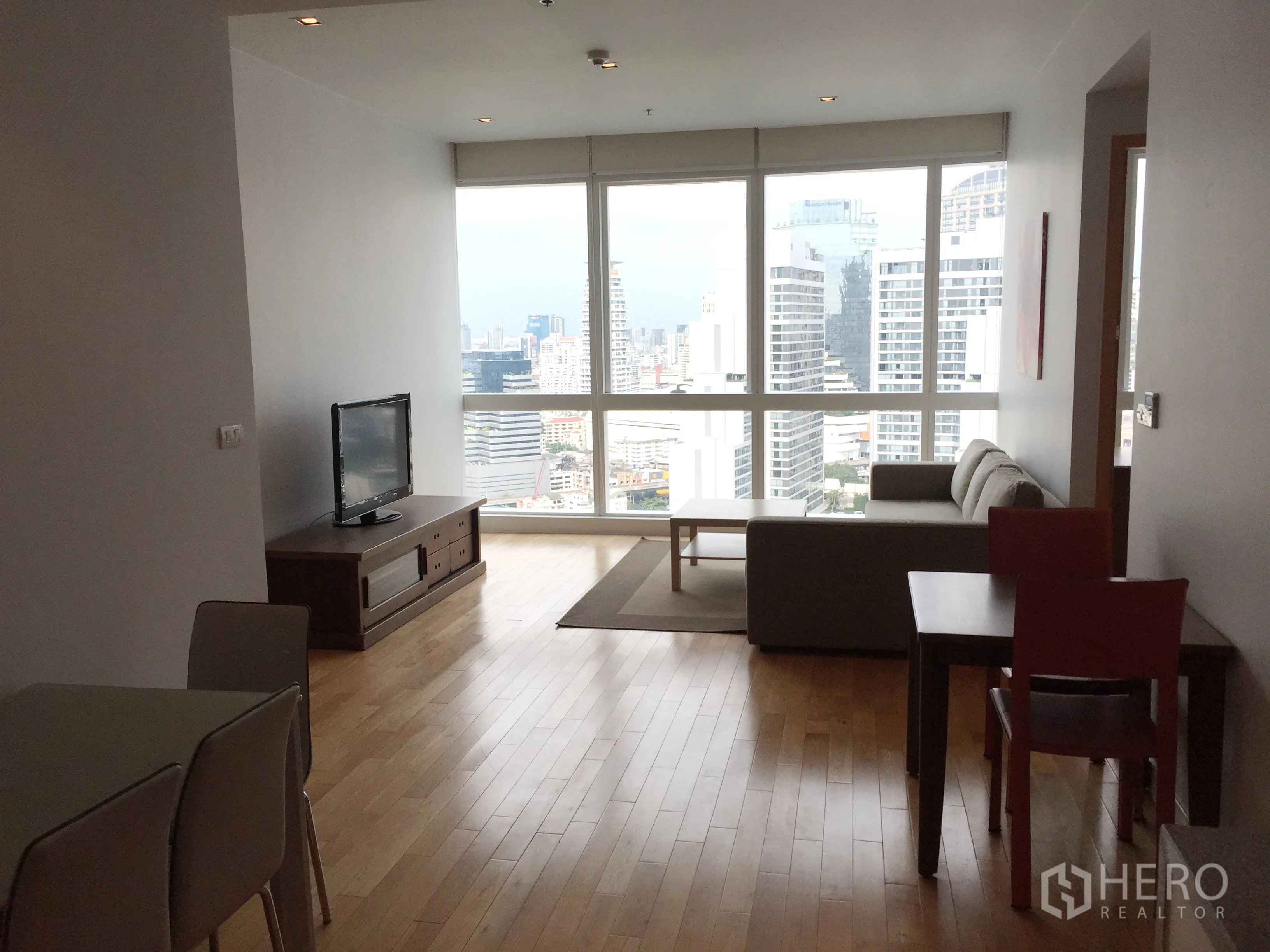 Condominium for rent in Khlong Toei, Bangkok - Bright living and dining area with floor-to-ceiling windows and panoramic Bangkok skyline view.