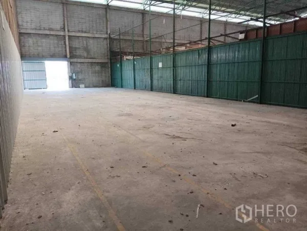 货栈 出租在Prawet, Bangkok - 开阔存储区，采光屋面板与绿色金属隔断。