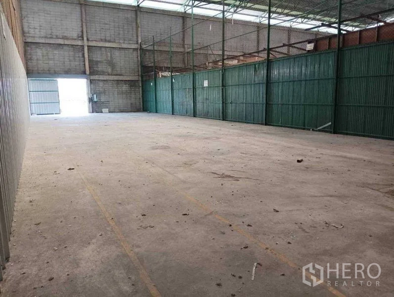 货栈 出租在Prawet, Bangkok - 开阔存储区，采光屋面板与绿色金属隔断。