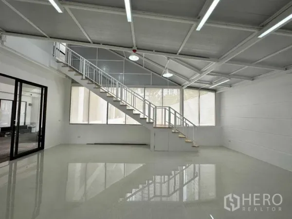 Office Space for rent or sale in Khlong Toei, Bangkok - Bright open office with long staircase, high sloped ceiling and expansive windows.