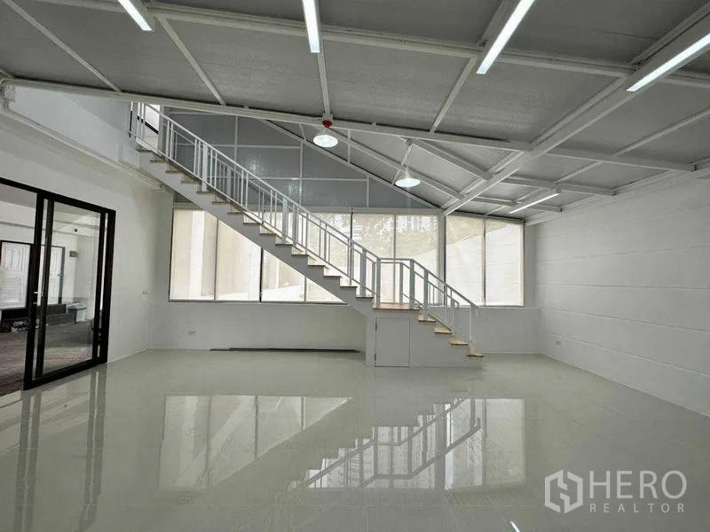 Office Space for rent or sale in Khlong Toei, Bangkok - Bright open office with long staircase, high sloped ceiling and expansive windows.