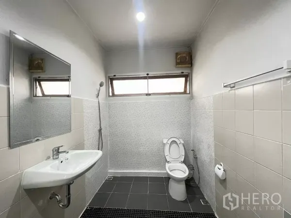 Home Office for rent in Din Daeng, Bangkok - Tiled bathroom featuring a shower zone, wall‑hung sink and toilet beneath clerestory windows.