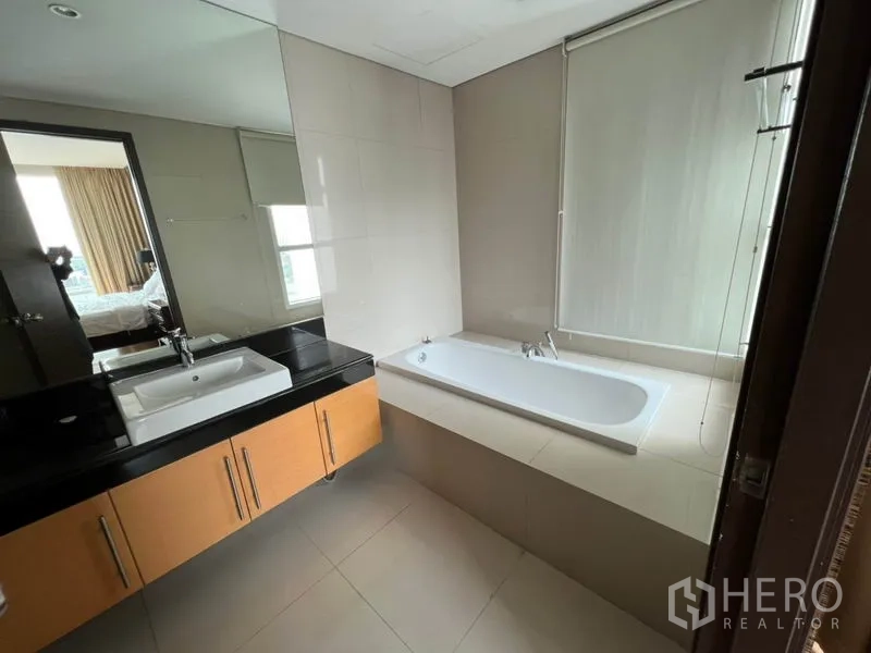 公寓 出租在Watthana, Bangkok - 主卫配嵌入式浴缸、宽台面洗手台与中性色瓷砖。