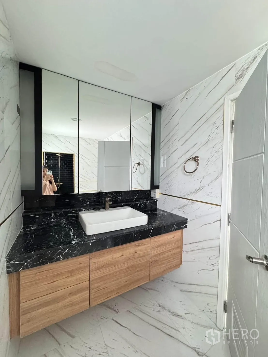 半独立式住宅 for rent or sale in Suan Luang, Bangkok - 卫浴梳洗台为黑色大理石台面，台上盆、木质柜与整面镜子。
