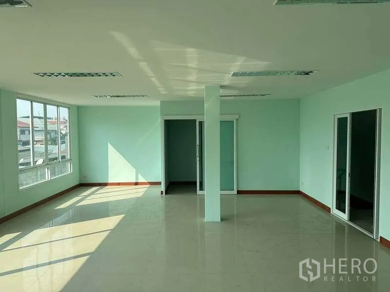 Warehouse for rent in Bang Phli, Samut Prakan - Open-plan office level with sliding glass doors, corner windows and a central column.